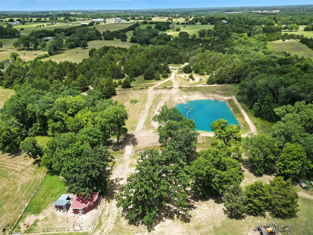 an aerial view of residential houses with outdoor space and trees