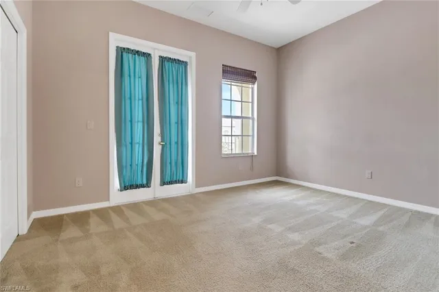 an empty room with windows and ceiling fan