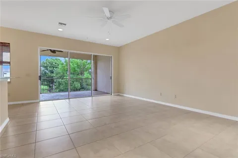 a view of a electric appliances in kitchen and empty room with wooden floor