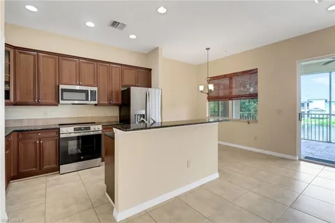 a kitchen with granite countertop a sink stove and refrigerator