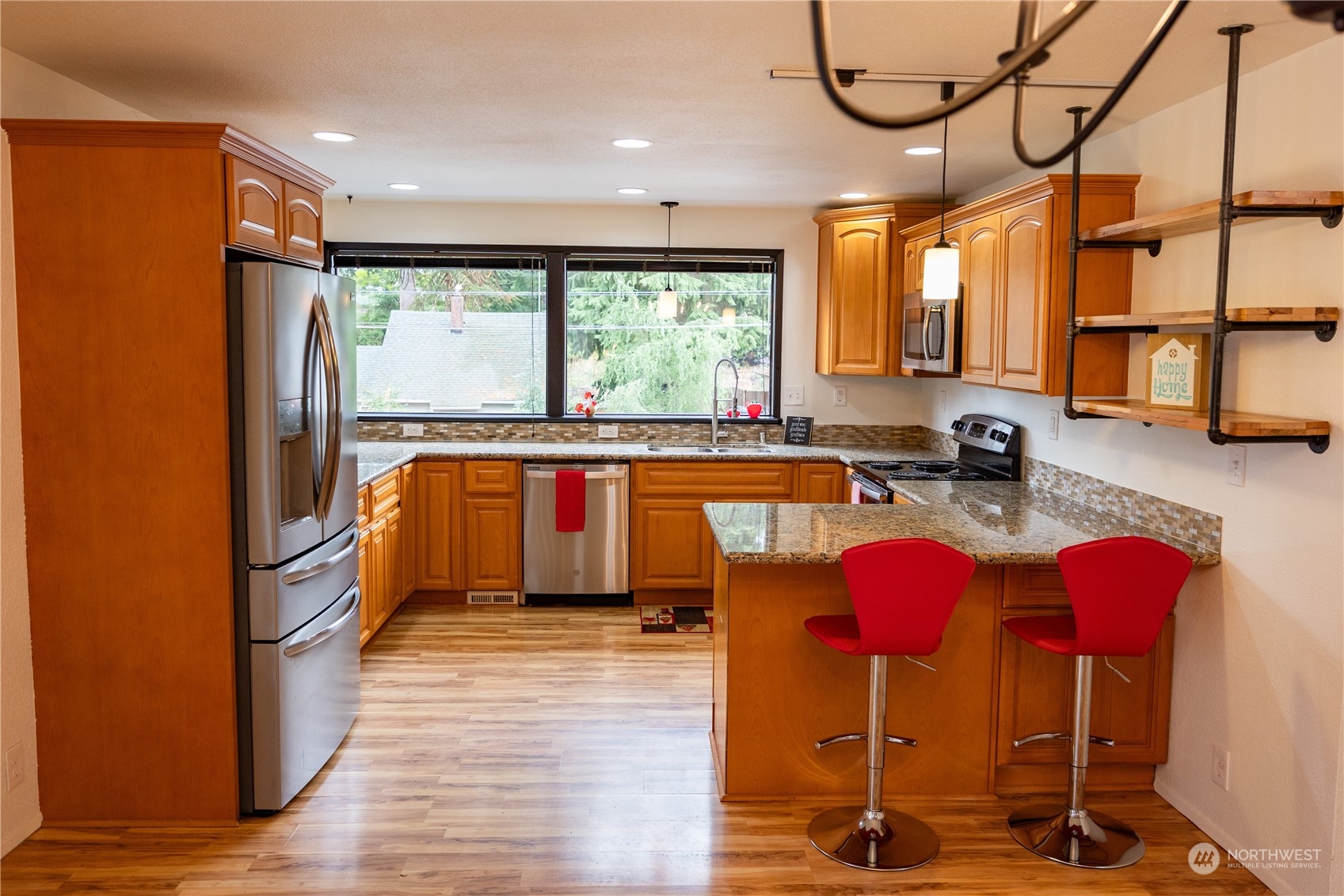 129 Del Monte Avenue Fircrest, WA 98466 - Photo 11 of 38 a kitchen with stainless steel appliances granite countertop a stove a sink dishwasher and a dining table with wooden floor