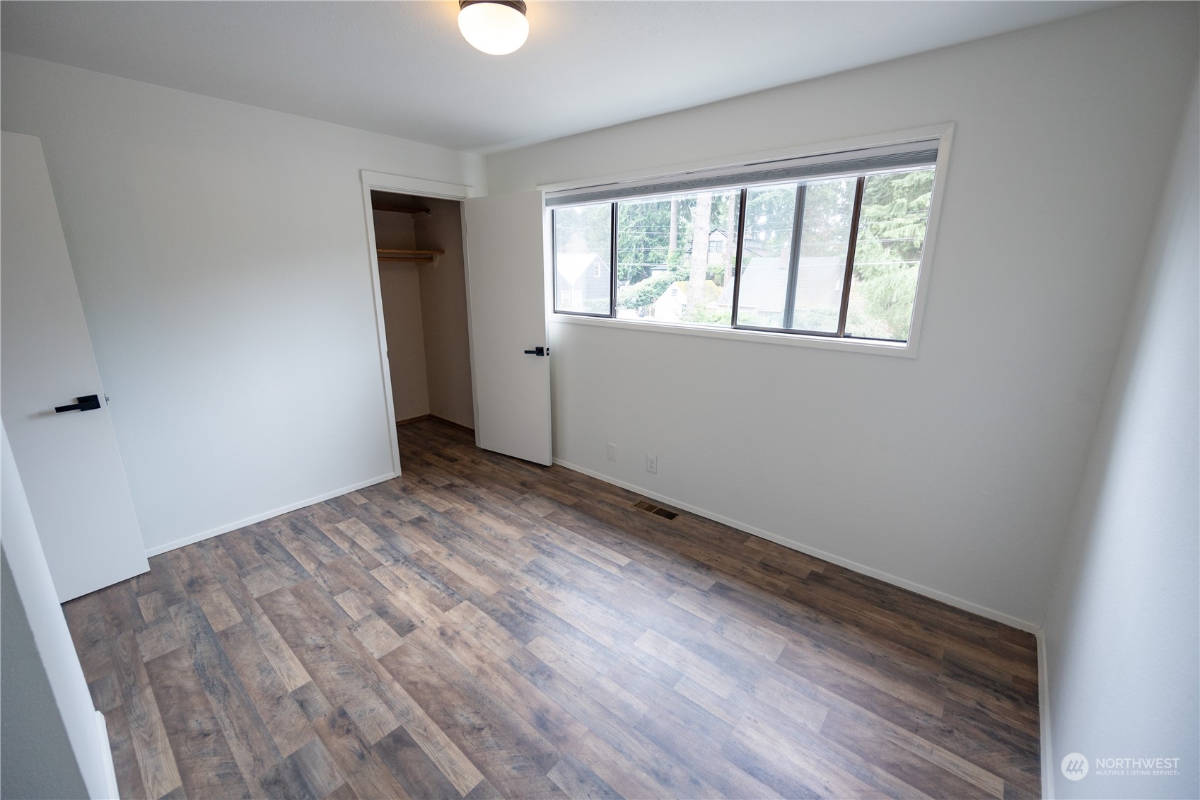 129 Del Monte Avenue Fircrest, WA 98466 - Photo 21 of 38 a view of an empty room with wooden floor and a window