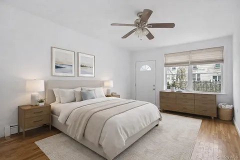 a bedroom with a bed and a dresser next to a window