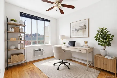 a view of a workspace with furniture and a window