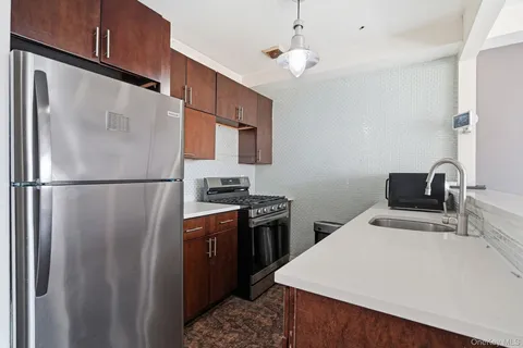 a kitchen with stainless steel appliances a refrigerator sink and stove