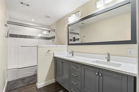 a bathroom with a double vanity sink and mirror
