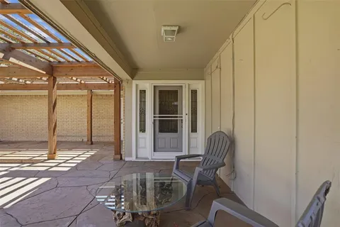 a living room with a chair and large windows