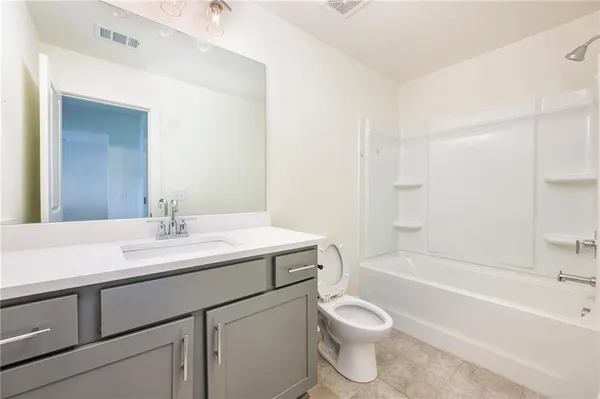 a bathroom with a sink toilet vanity tub and shower