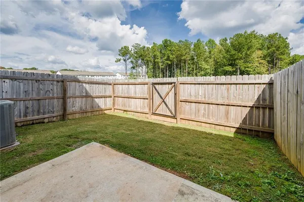 a view of a backyard with wooden fence