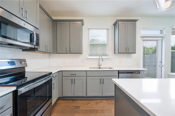 a kitchen with stainless steel appliances granite countertop a sink stove and microwave
