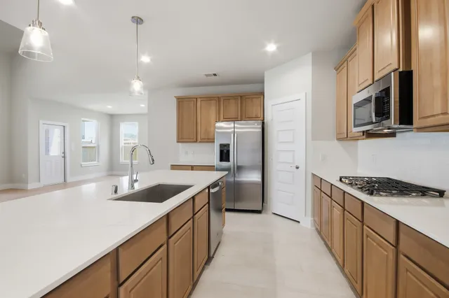 a kitchen with stainless steel appliances granite countertop a sink a stove and a refrigerator