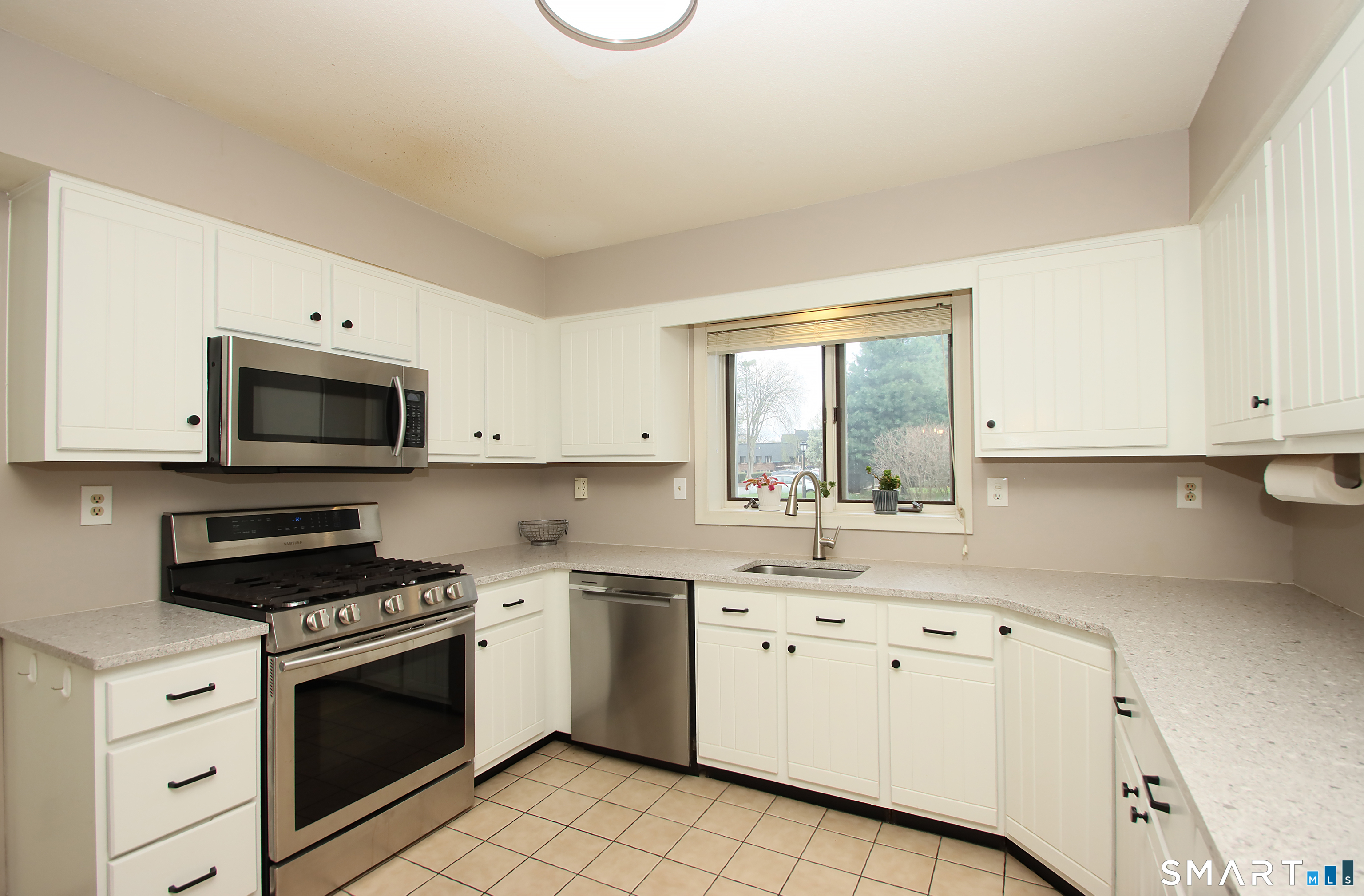 182 Main Street, Unit A Manchester, CT 06042 - Photo 8 of 34 Updated Kitchen with white cabinets, Quartz Countertops and Stainless Steel Appliances.