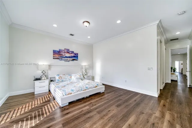 a bedroom with a bed and painting on the wall