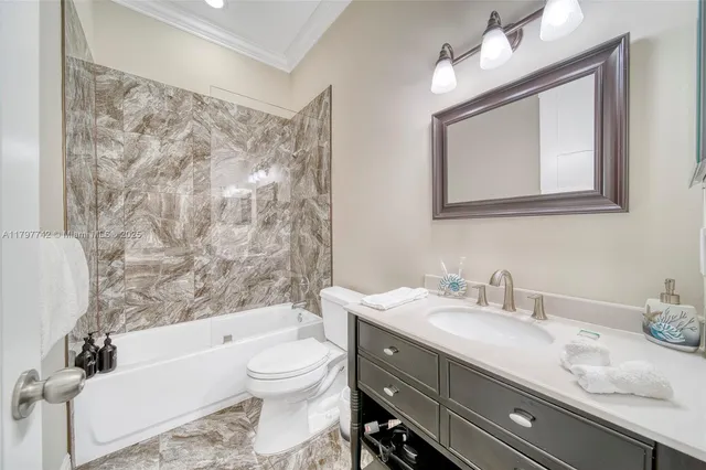a bathroom with a granite countertop sink toilet a mirror and bathtub