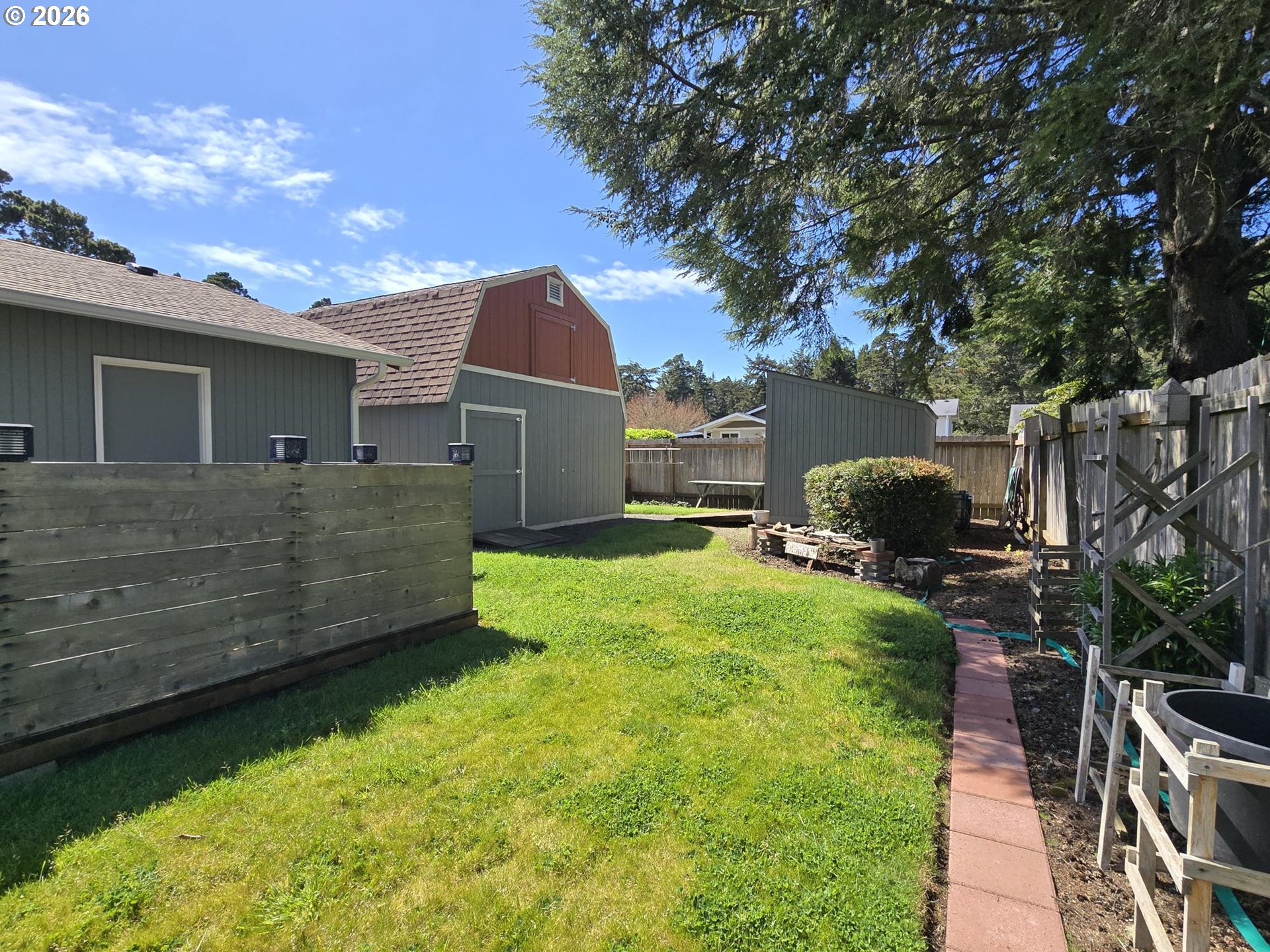 1265 34th Place Florence, OR 97439 - Photo 26 of 29 a view of a backyard with potted plants and large tree