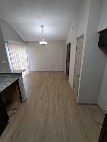 an empty room with wooden floor fireplace and windows