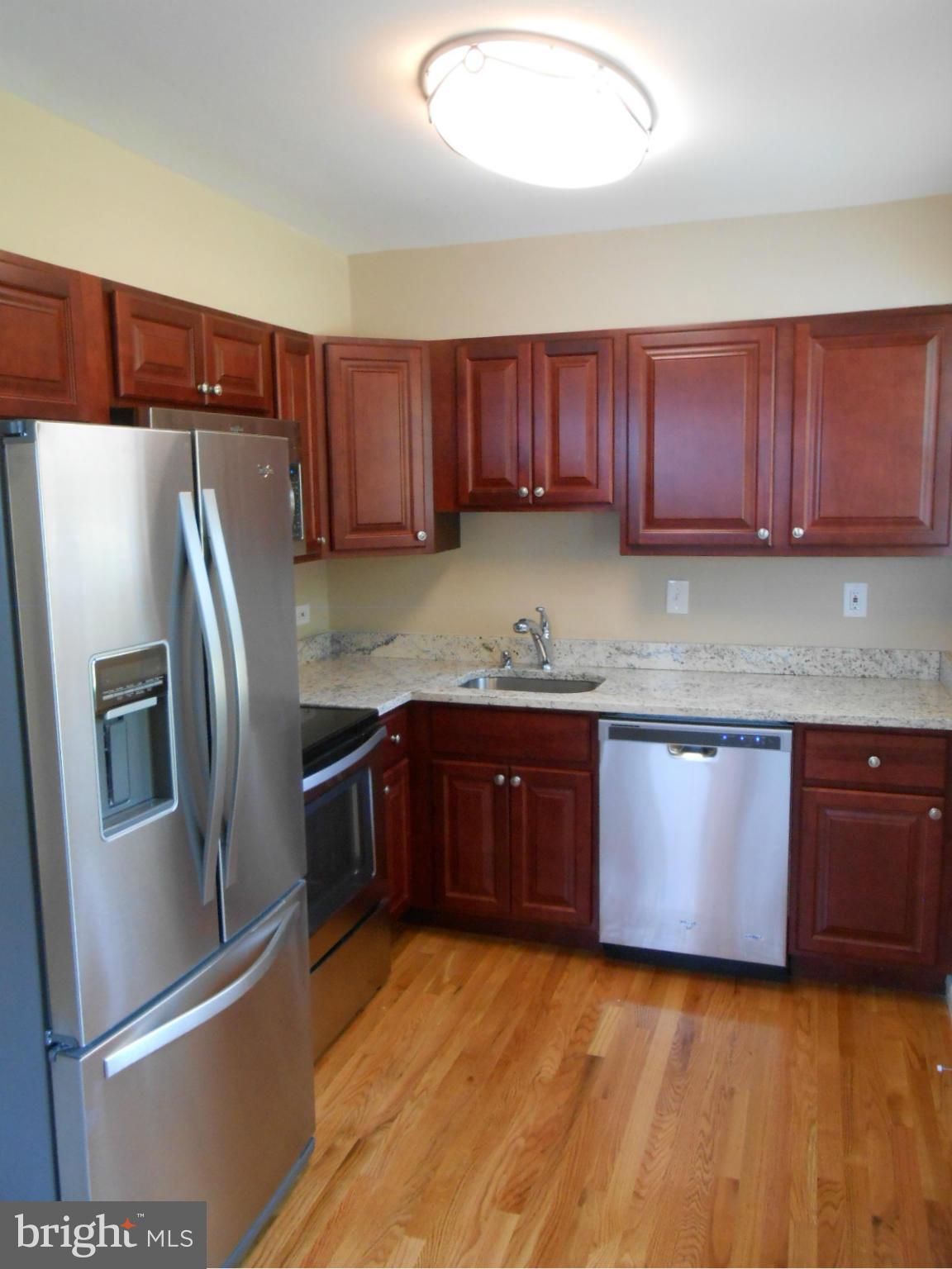 3916 Weller Road Silver Spring, MD 20906 - Photo 3 of 19 a kitchen with granite countertop stainless steel appliances and wooden cabinets