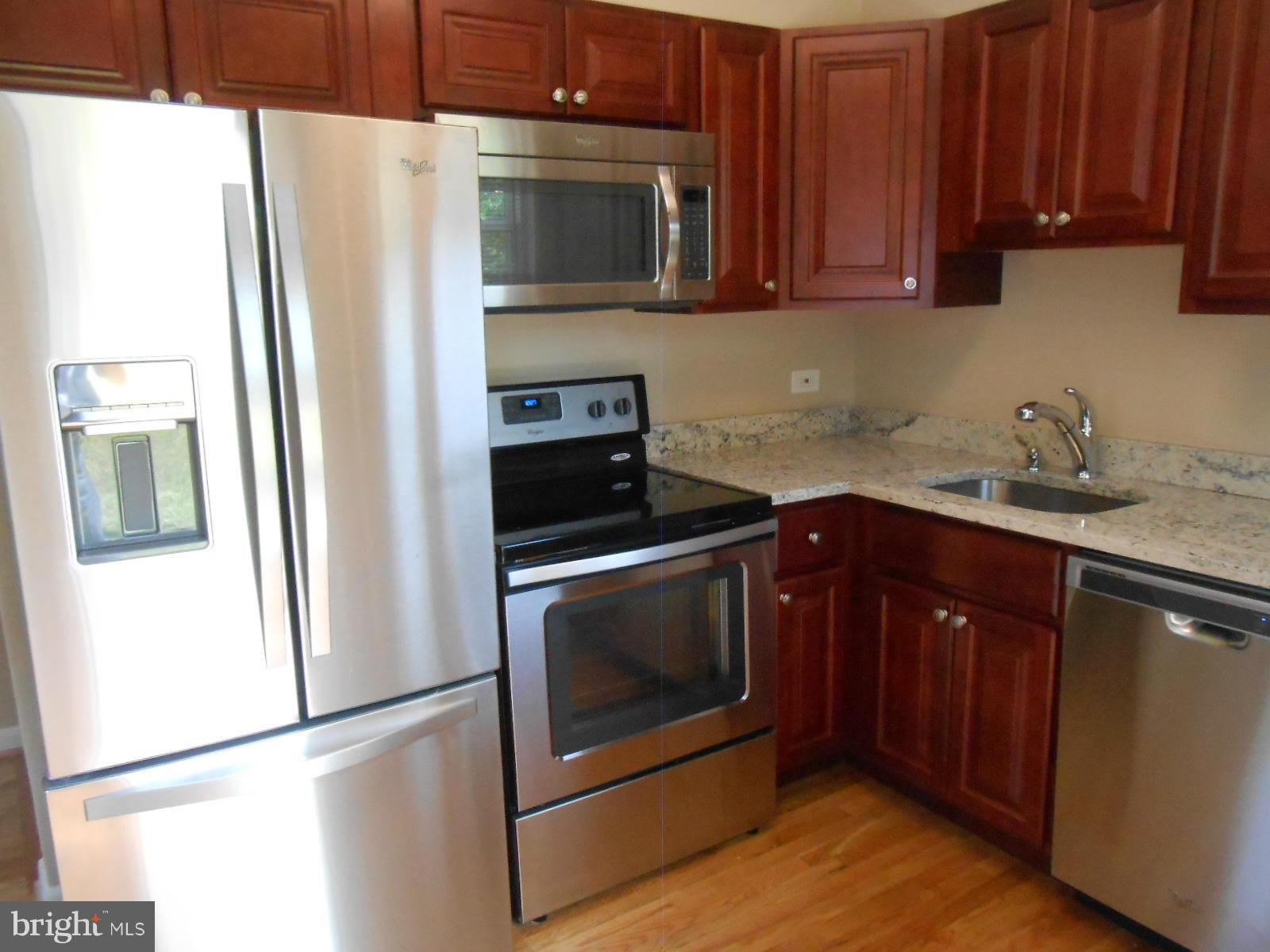3916 Weller Road Silver Spring, MD 20906 - Photo 4 of 19 a kitchen with stainless steel appliances granite countertop a refrigerator stove and microwave