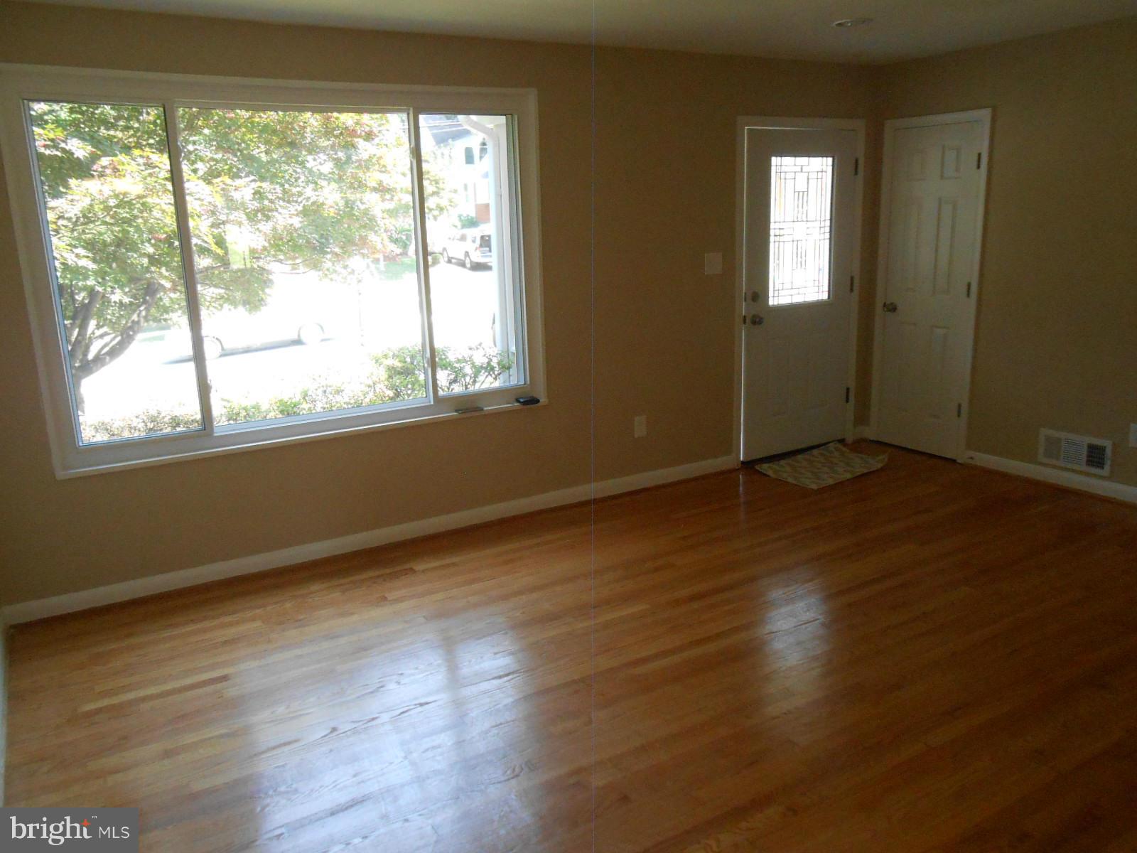 3916 Weller Road Silver Spring, MD 20906 - Photo 6 of 19 a view of an empty room with wooden floor and a window