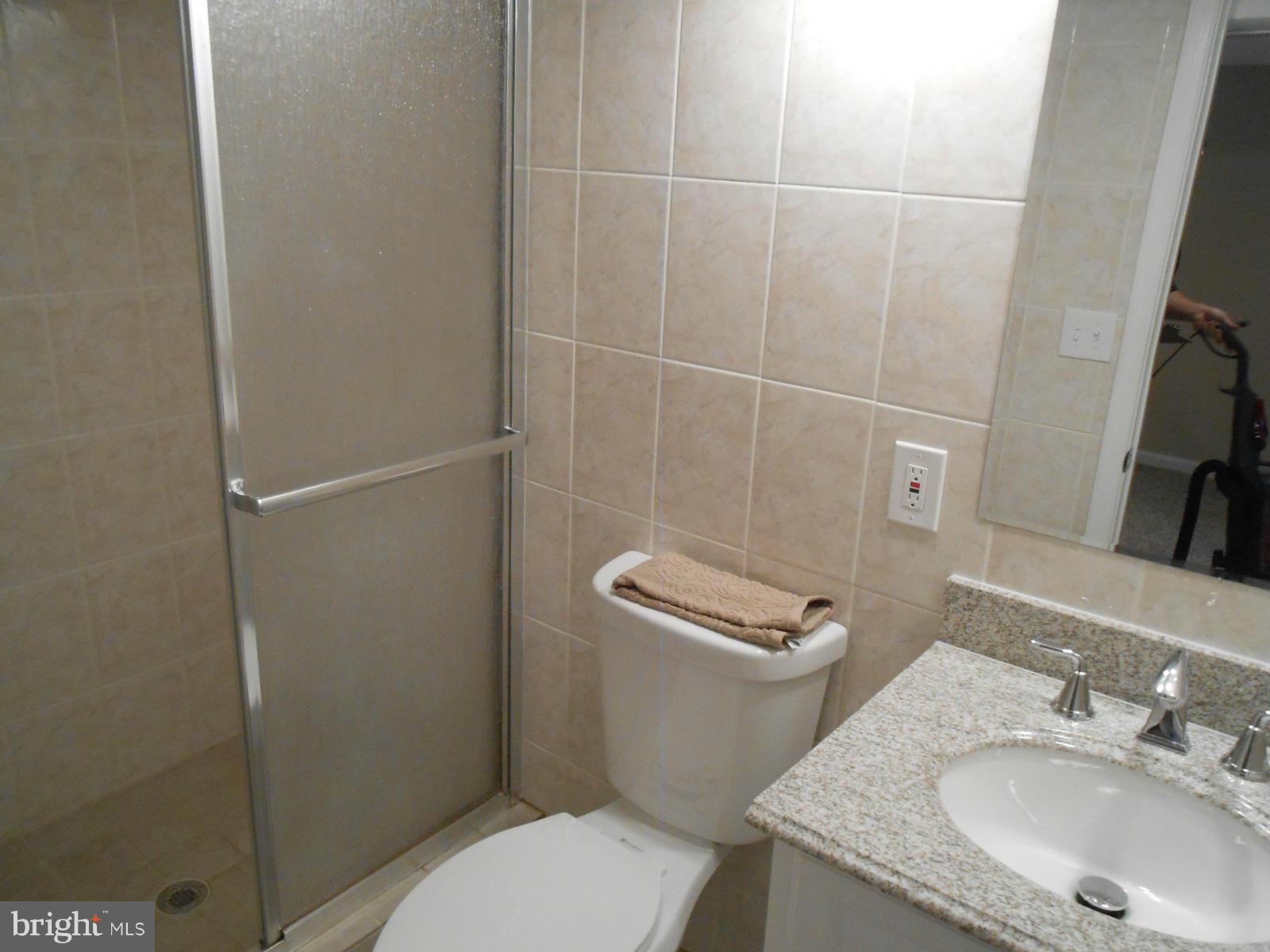 3916 Weller Road Silver Spring, MD 20906 - Photo 10 of 19 a bathroom with a granite countertop toilet sink and mirror
