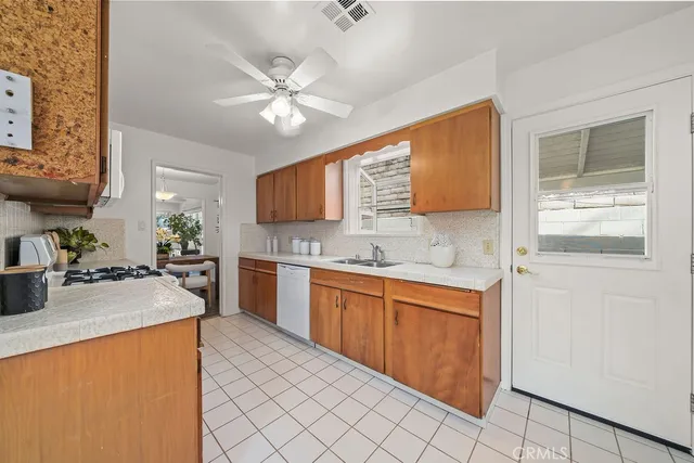 a kitchen with stainless steel appliances granite countertop a sink cabinets and wooden floor
