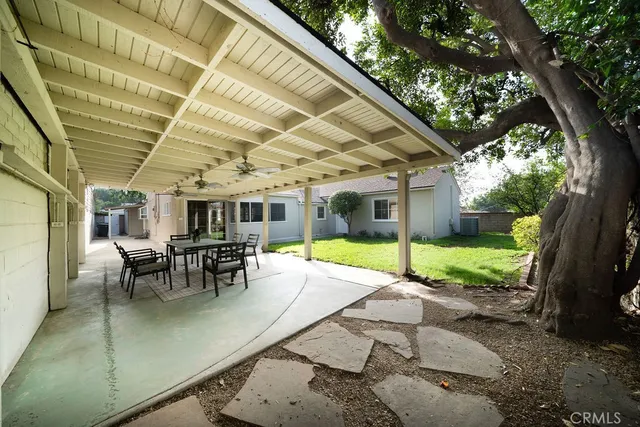 a view of a patio with table and chairs and floor to ceiling window