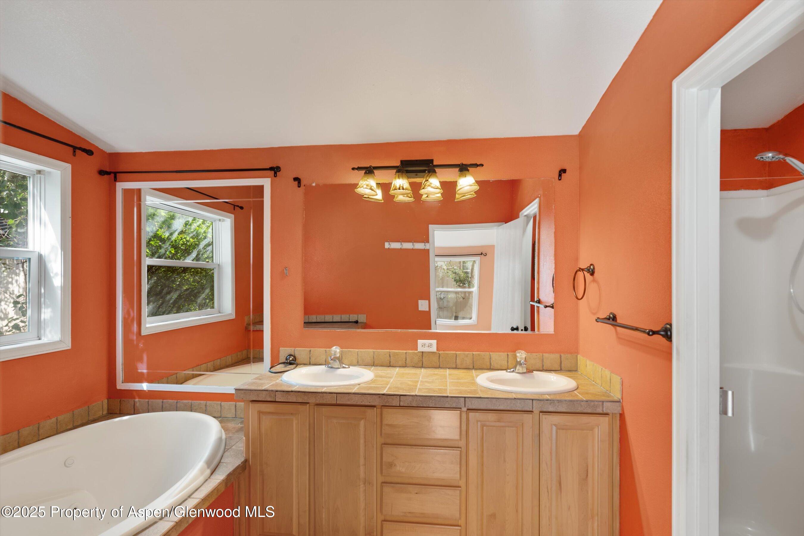 111 Ridge Trail Aspen, CO 81611 - Photo 14 of 37 a bathroom with a granite countertop tub a sink and a large mirror