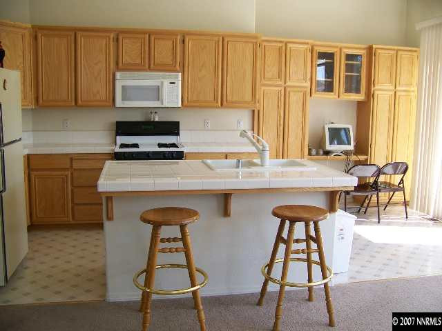 9631 Comanche Moon Drive Reno, NV 89521 - Photo 2 of 9 a kitchen with stainless steel appliances granite countertop a stove a sink and a microwave