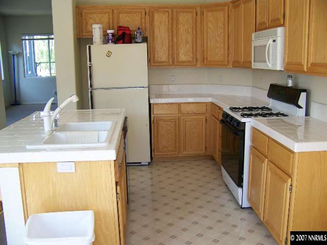 9631 Comanche Moon Drive Reno, NV 89521 - Photo 3 of 9 a kitchen with a sink stove and refrigerator