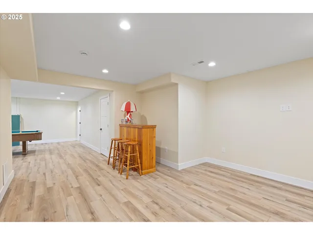 a room with pool table and wooden floor
