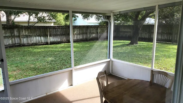 a view of a porch with chairs and backyard
