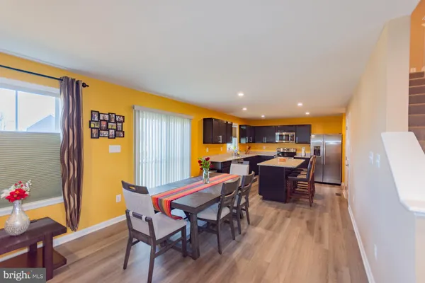 a living room with stainless steel appliances kitchen island granite countertop furniture a sink and a large window