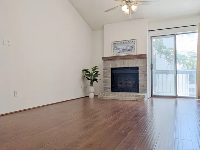 wooden floor fireplace and windows in an empty room