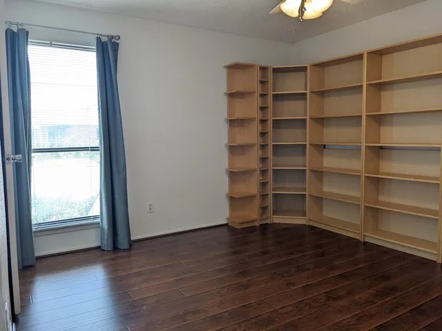 a view of a room with wooden floor and a window