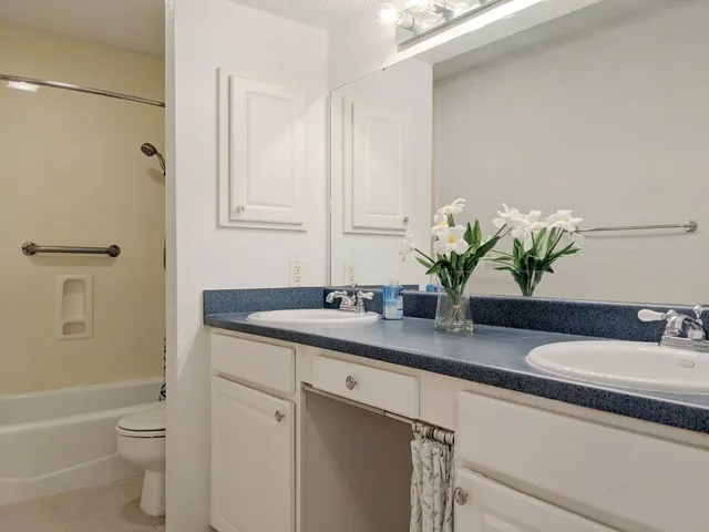a bathroom with a granite countertop toilet a sink and a bathtub