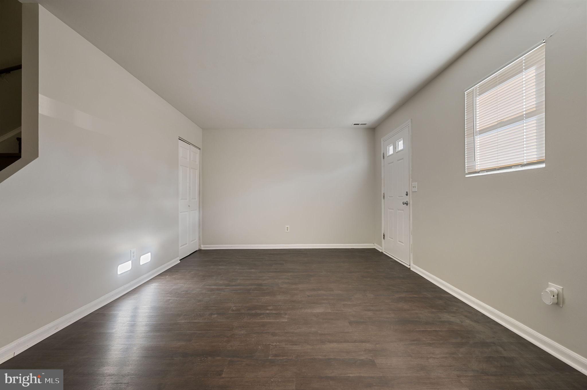 33 Spruance Road Dover, DE 19901 - Photo 3 of 20 a view of an empty room with wooden floor and a window