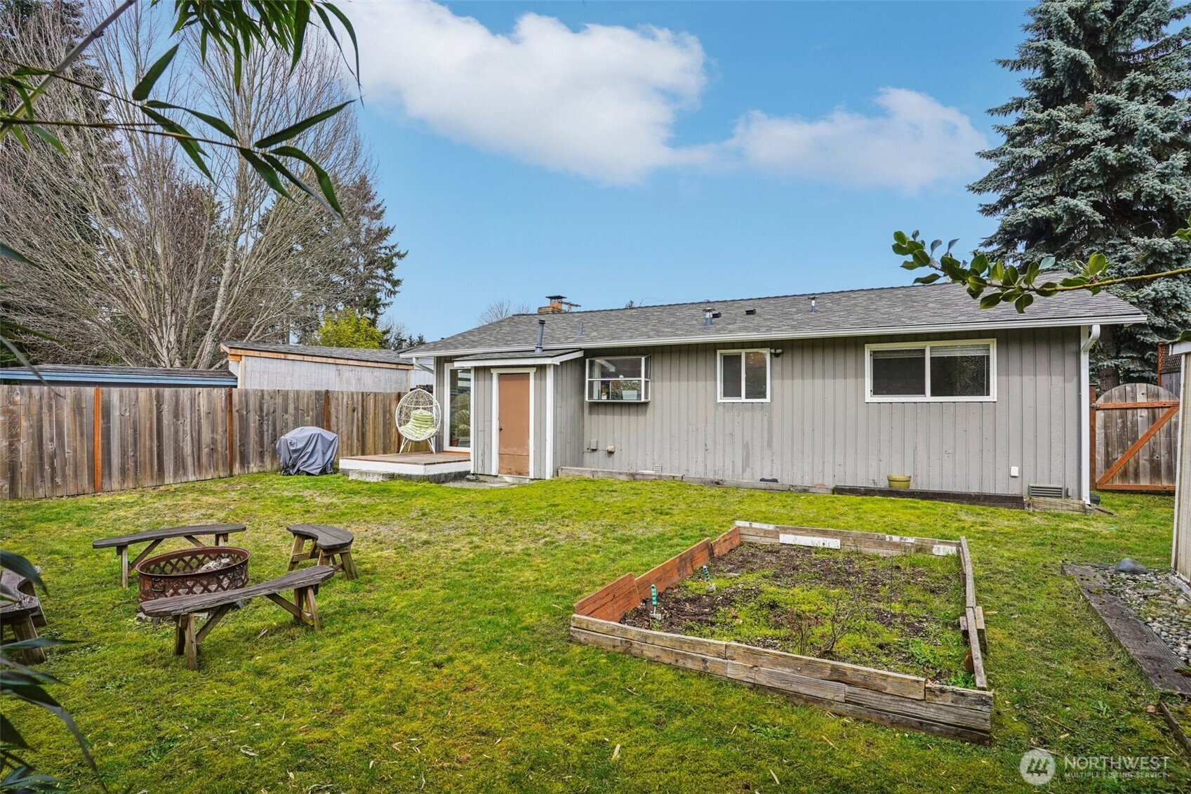 3709 Northeast 9th Court Renton, WA 98056 - Photo 18 of 21 a view of a backyard with table and chairs with wooden fence and plants