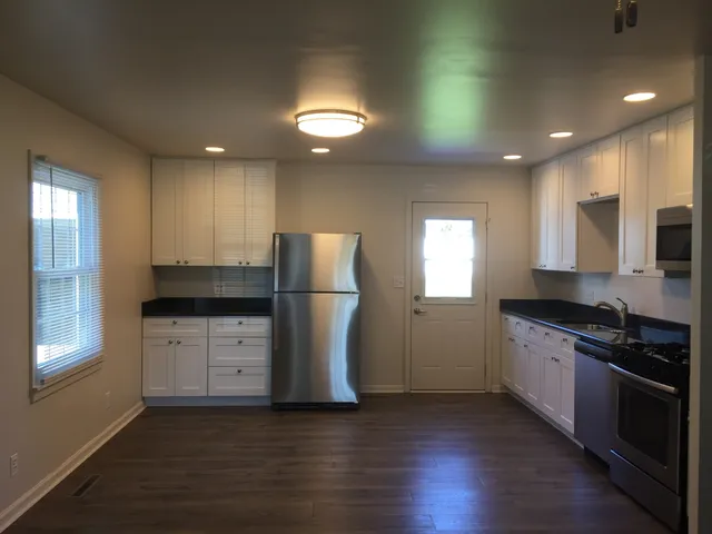 a kitchen with granite countertop appliances a sink and a refrigerator