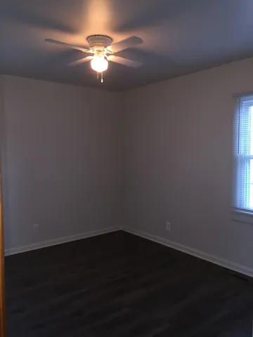 a view of a room with wooden floor and fan