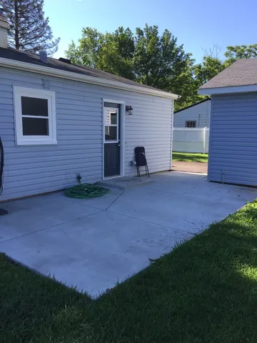 a view of a backyard with plants and a brick wall
