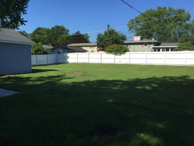 a view of three house with a big yard