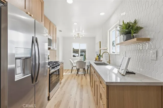 a kitchen with stainless steel appliances kitchen island hardwood floor and refrigerator