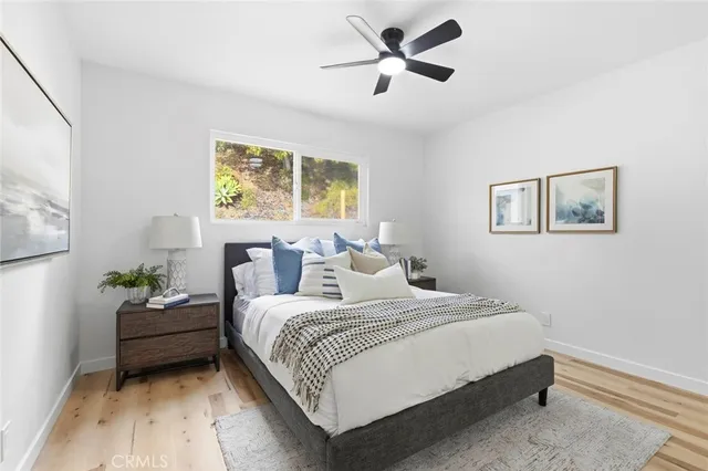 a bedroom with a bed chandelier and a window