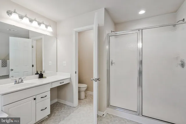 a bathroom with a double vanity sink mirror and toilet