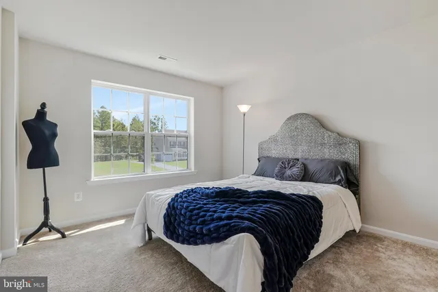 a bedroom with a bed a lamp and a window