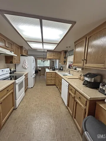 a bedroom with a large bed a chandelier and dresser