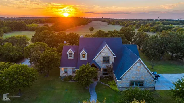an aerial view of house with yard and mountain in the background