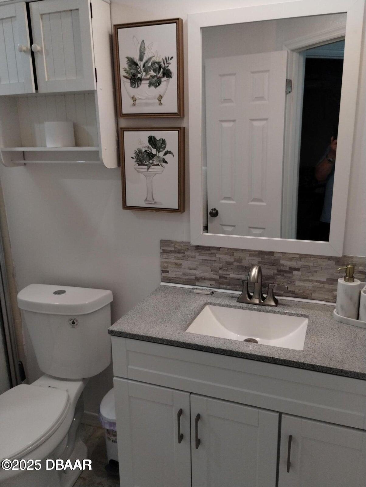 962 Stonybrook Circle Port Orange, FL 32127 - Photo 13 of 15 a bathroom with a toilet sink and mirror