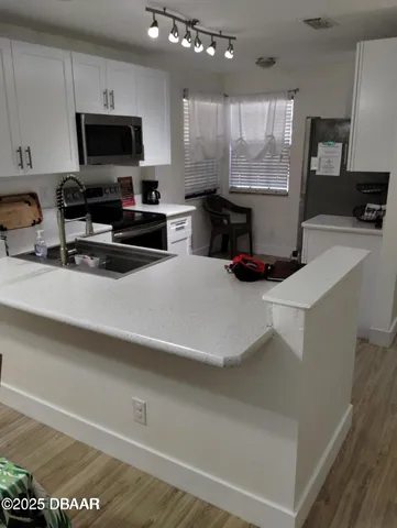 a view of a room with wooden floor and a ceiling fan