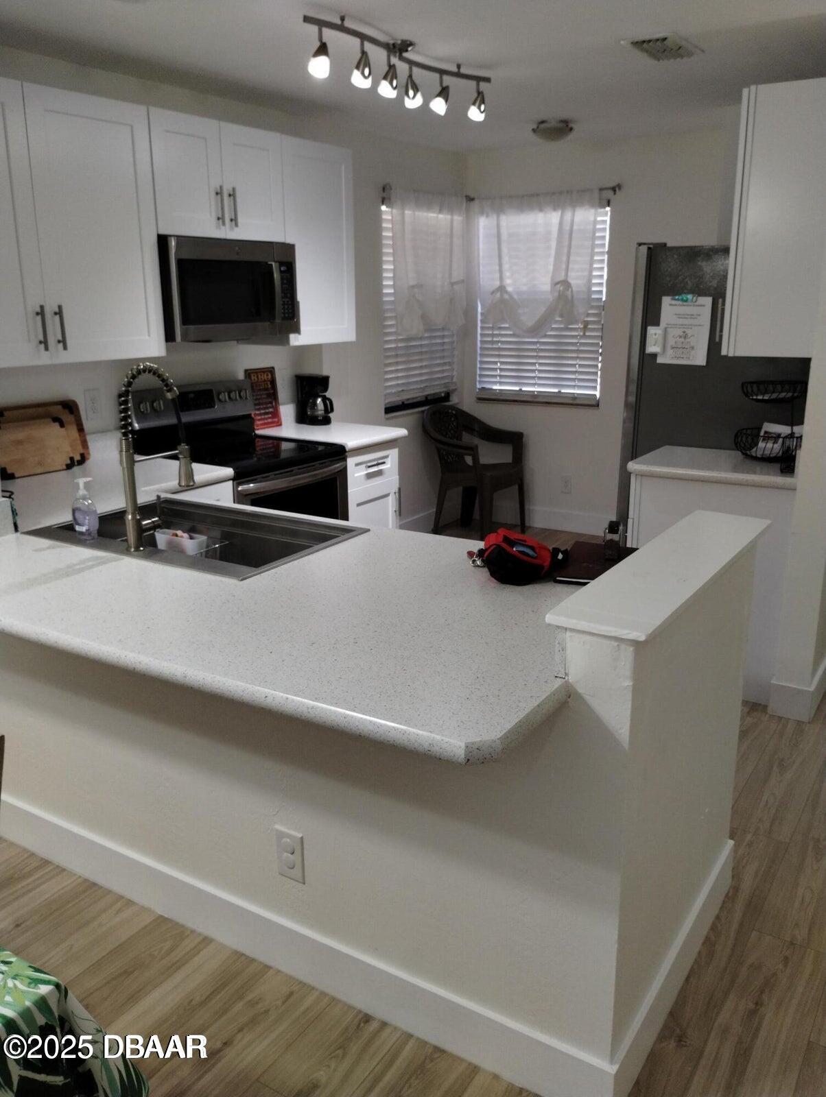 962 Stonybrook Circle Port Orange, FL 32127 - Photo 10 of 15 a kitchen with stainless steel appliances a stove a microwave and a sink